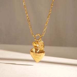 Detailed view of gold heart locket with I love you engraving and star pendant