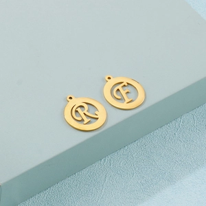 Macro shot of gold stainless steel alphabet pendants with R and F letter cutouts