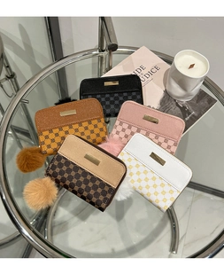 Mini plush coin purses in multiple colors displayed on a glass table with artistic decor