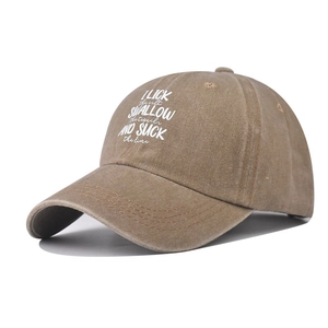 Detail view of washed tan cotton baseball cap with white embroidered text on crown