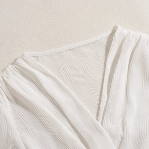 Detailed close-up of white lantern sleeve jacket featuring delicate rippled texture fabric