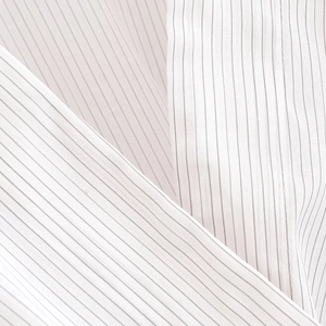 Detailed macro view of white pinstripe woven fabric with elegant black vertical stripes