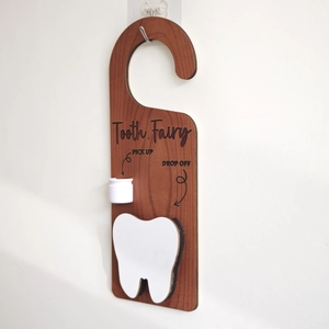 Detailed close-up of a wooden Tooth Fairy door hanger with pick up and drop off features