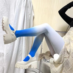 Detail of white platform Mary Jane shoes paired with blue gradient velvet pantyhose