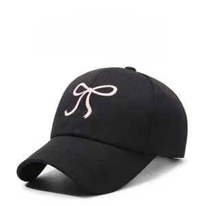 Vue détaillée de la broderie nœud rose sur une casquette de baseball noire