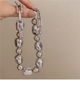 Detailed close-up of French style irregular silver bead necklace with bold metal links