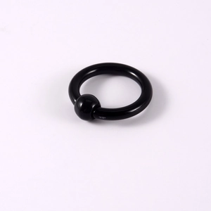 Polished black acrylic captive bead ring for nose or ear piercings on white background