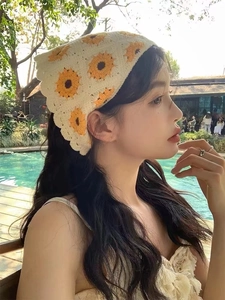 Detailed knit texture of a beige crochet bandana with yellow sunflower floral patterns