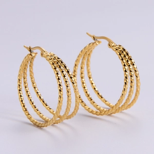 Detail of gold twisted stainless steel hoop earrings with a triple layer textured design