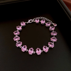 Detail of pink oval zircon bracelet with silver chain on black leather background