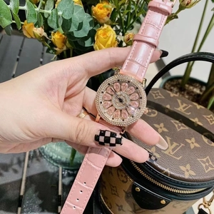 Close-up of pink leather watch band and floral crystal dial on luxury spinning watch