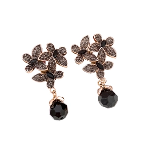 Vintage floral drop earrings with rose gold metal and black crystals on white background