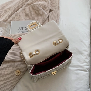 Chic tweed crossbody bag with pearl trim, gold chain, and red interior in top view