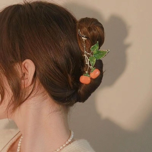 Elegant hand-painted orange persimmon hair claw clip for women on minimalist background