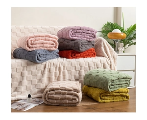 Detail showing various colors of thick checkered blankets with 3D waffle texture on a sofa