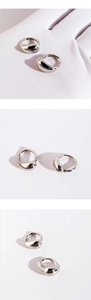 Détail macro de boucles d'oreilles créoles goutte en argent avec fini métallique poli