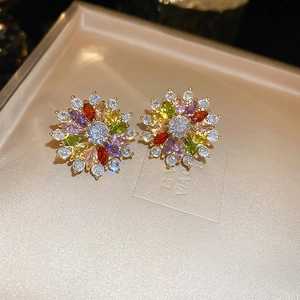 Macro detail of gold-plated floral earrings with colorful marquise zircons and crystals