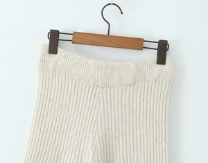 Detailansicht der cremefarbenen Strickhose mit hoch tailliertem Rippbund und vertikaler Textur