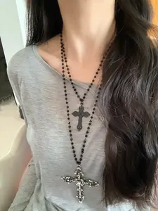 Detail of gothic black layered beaded necklace with crystal studded cross pendant