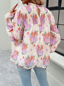 Detail view of the floral print shirt featuring pleated back design and ruffled high neck