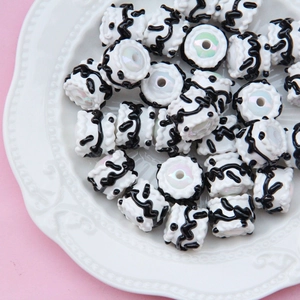 Macro shot of white cylindrical resin beads with black wave patterns for DIY crafts