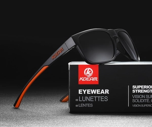 Detail of matte black and orange outdoor sports polarized sunglasses on brand packaging