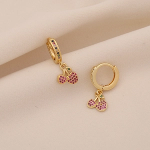 Elegant gold cherry earrings featuring red rhinestones and green gems on silk fabric