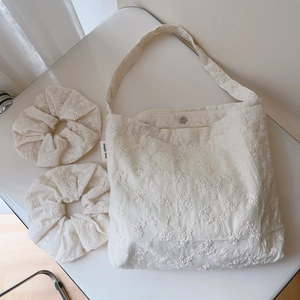Detail of floral embroidery on cotton tote bag with magnetic clasp and scrunchies