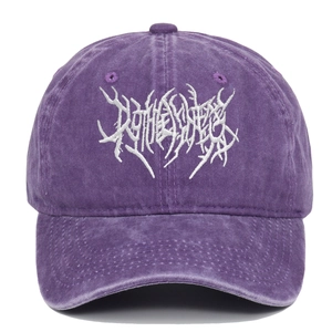 Close-up of white gothic embroidery on vintage washed purple cotton punk baseball cap