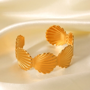 Bracelet jonc ouvert en acier inoxydable doré 18K sur fond de soie beige élégant