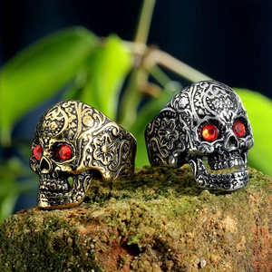 Vintage skull rings in gold and silver with red gem eyes on natural moss stone