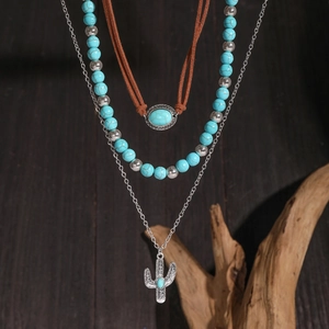 Close-up of bohemian layered necklace with cactus charm and turquoise beaded details