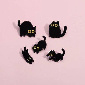 Juego de cinco pines de esmalte de gato negro con ojos amarillos sobre fondo rosa