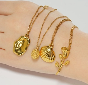 Détail de quatre colliers en plaqué or 18K avec pendentifs rose et coquillage