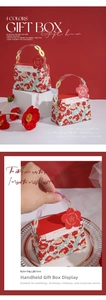 Close-up of red floral gift box featuring a plastic chain handle and decorative tag