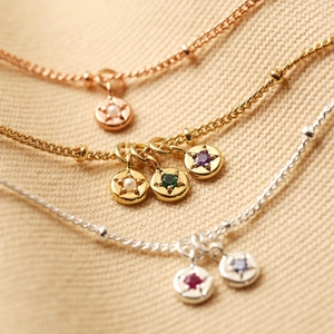 Three dainty birthstone necklaces in gold, silver, and rose gold with colorful zircon stones