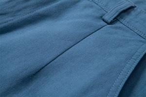 Macro detail of blue cotton twill fabric showing reinforced double stitching and texture