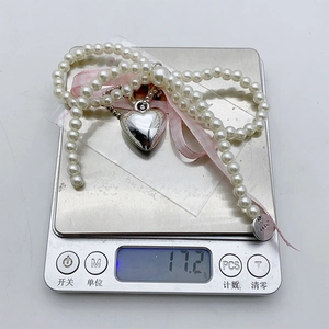 Detailed view of pearl necklace with silver heart pendant weighing 17.2 grams