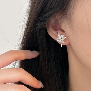Detailed view of 925 silver flower stud earring worn on ear with polished finish