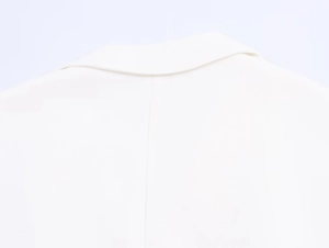 Close-up of the collar tailoring and white twill fabric texture of the linen blend vest