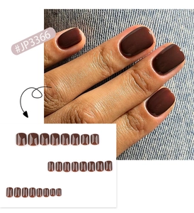 Vista detallada del juego de uñas postizas cuadradas marrón oscuro con modelo de mano