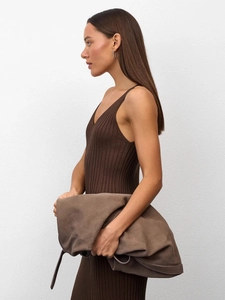 Detail of dark brown suede clutch bag paired with slim-fit knit dress for women