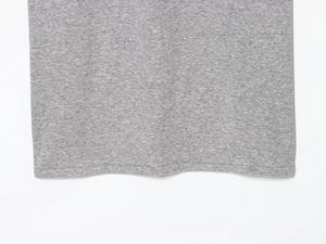 Detailed close-up of grey knit polo hem showing professional double-needle stitching