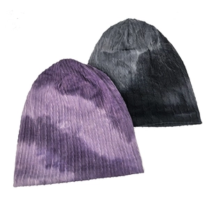 Detailed view of tie-dye stripe beanies featuring vertical cable knit texture and soft fabric