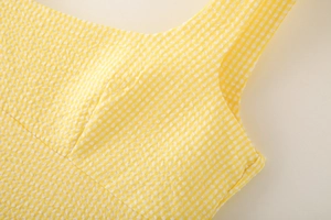 Macro detail of yellow and white gingham seersucker fabric texture for women dress