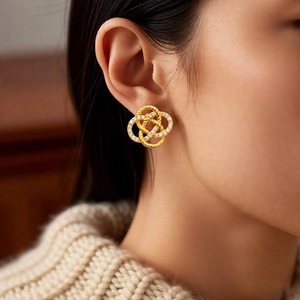Close-up of vintage gold knotted hoop earrings with pavé zircons on a model