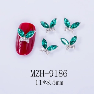 Detail of green butterfly nail charms showing size 11x8.5mm with horse eye gems