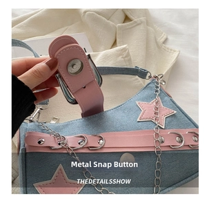 Close-up of the metal magnetic buckle on the denim and pink leather shoulder bag