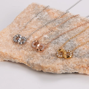 Three infinity necklaces in silver, rose gold and gold finishes on natural stone base
