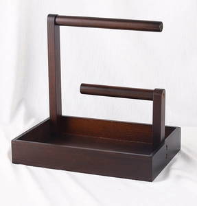 Macro shot of two-tier walnut wood jewelry stand with hanging bars and bottom tray
